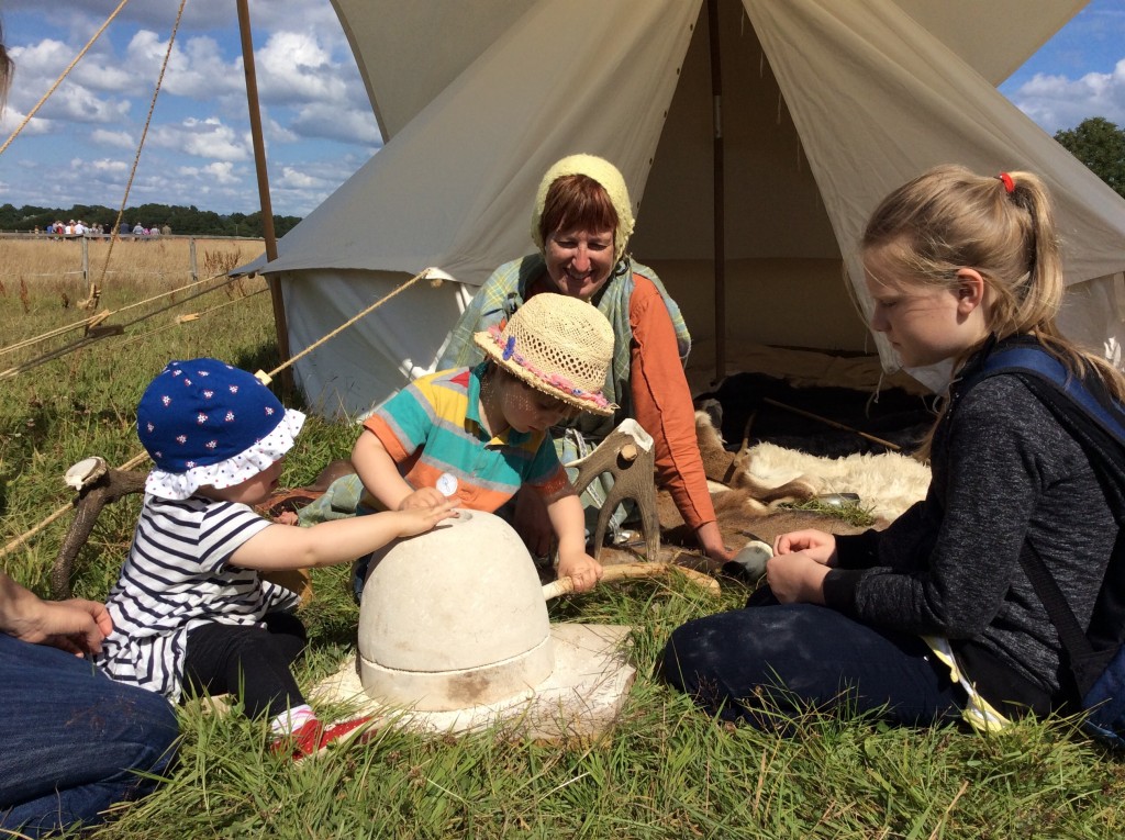 Young visitors learn to use an Iron Age quern